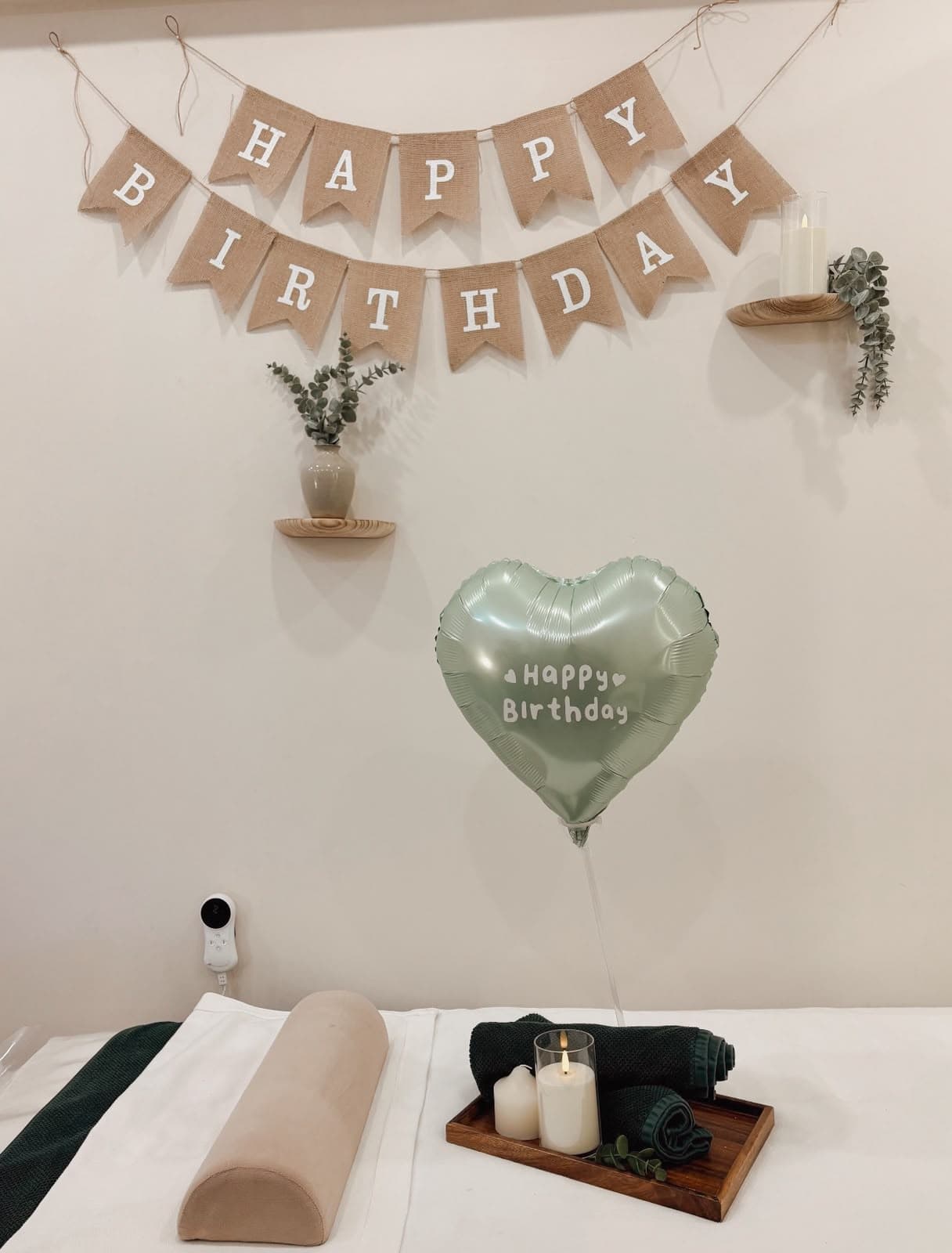 Cabina de Sairea decorada con letrero Happy Birthday, globo de corazón, velas y eucalipto